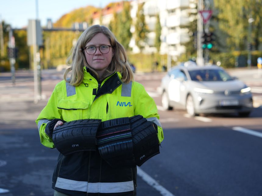 Woman holding large parts of car tires