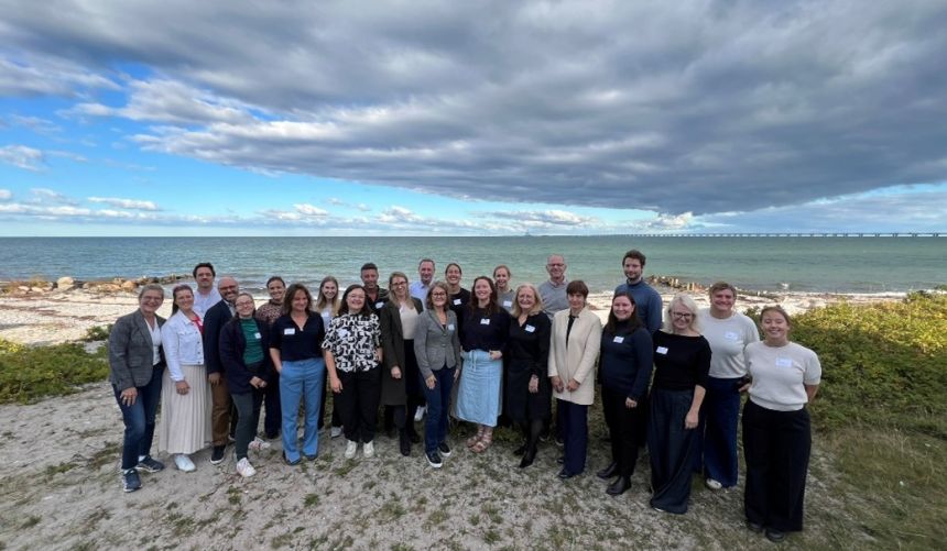 BlueActionBanos team (around 25 people) pose for a photo at the beach.