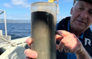 Mann som peker på rør med sediment