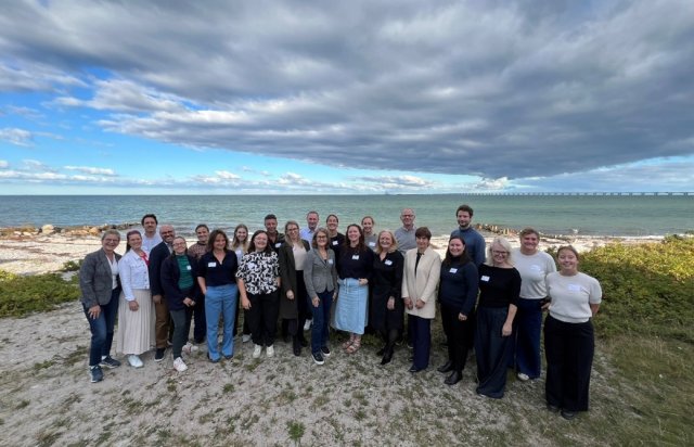 BlueActionBanos team (ca. 25 mennesker) smiler til kamera på stranden.